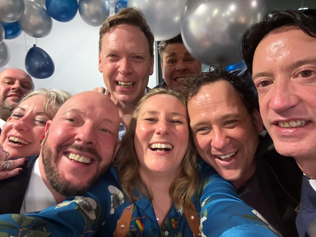 Groom and guests taking a group selfie at a wedding at Edes House, Chichester