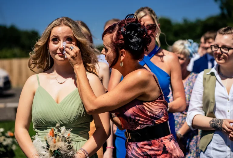 bridesmaid having tear wiped away during ceremony at Southlands Barn