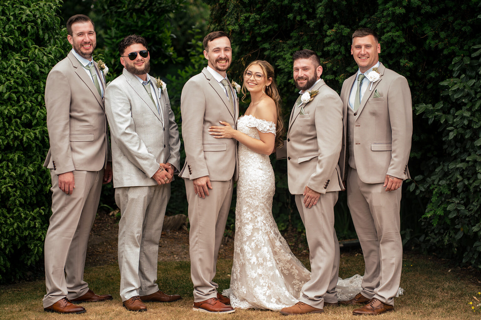 Bride with the groomsmen in the gardens
