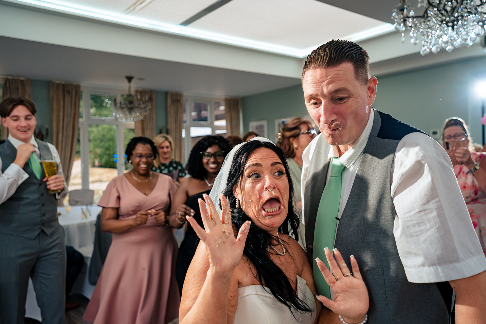 Playful cake cutting at a Farnham House Hotel wedding, Surrey