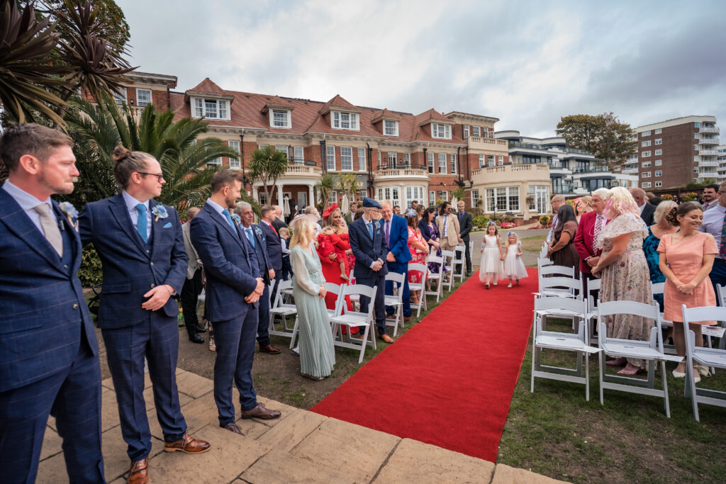 Groom and groomsmen waiting at the outdoor ceremony on the lawn at Hotel Miramar Bournemouth