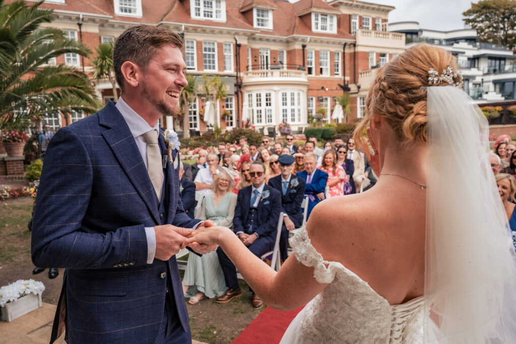 Groom placing the ring on the bride's finger at Hotel Miramar Bournemouth