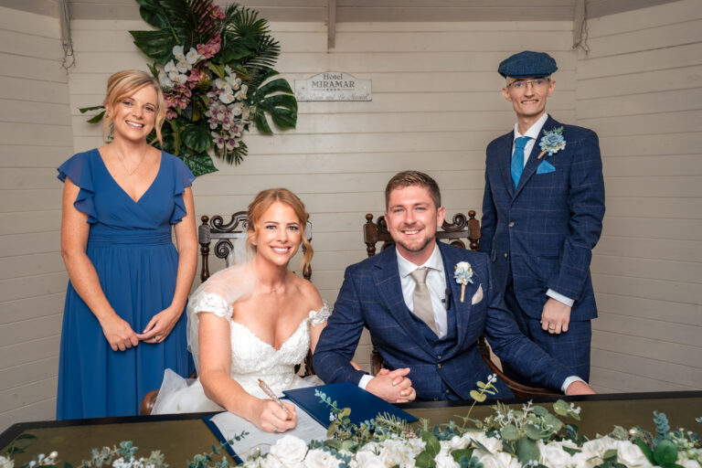 Bride and groom signing the register with their witnesses at Hotel Miramar