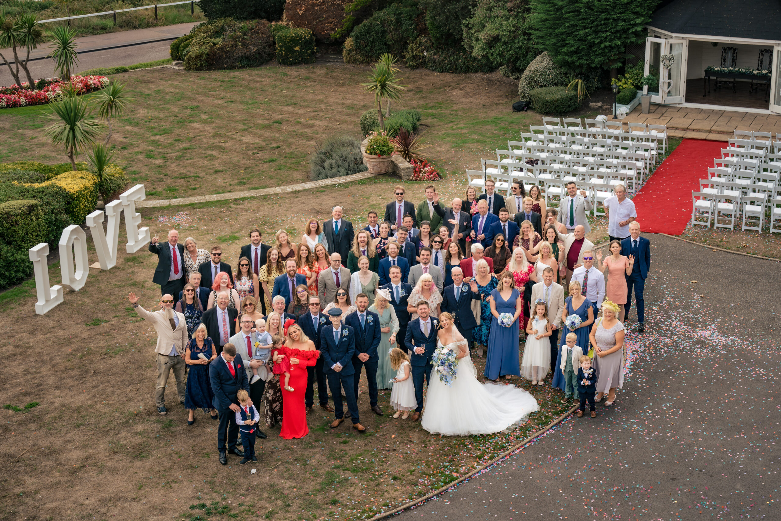 Big group photo from above with all the wedding guests and giant LOVE letters at Hotel Miramar
