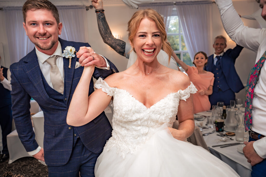 Bride and groom laughing with guests at their Hotel Miramar wedding breakfast