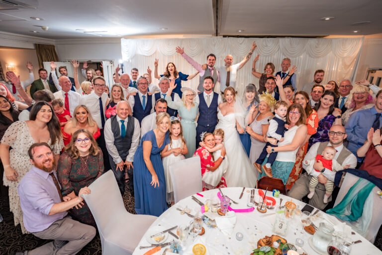 Whole room of wedding guests cheering with arms in the air at Hotel Miramar Bournemouth