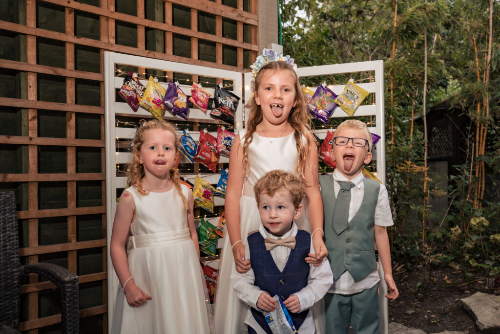 Flower girls and pageboys pulling funny faces by the sweet wall at Hotel Miramar