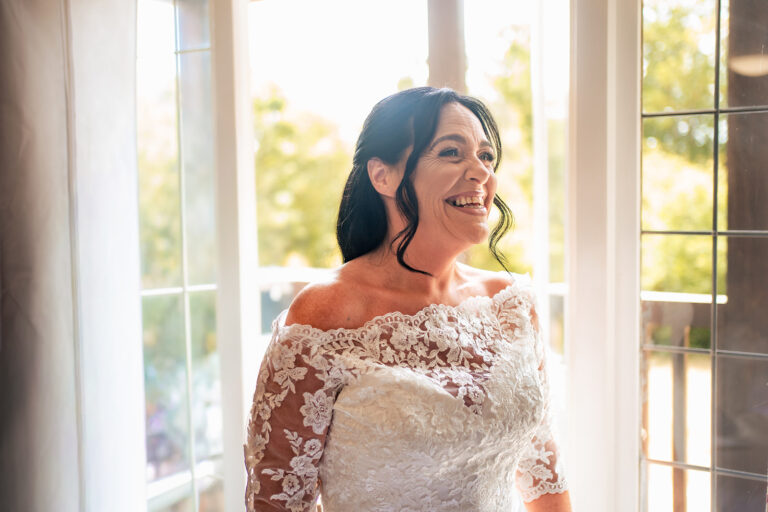 Bride in soft window light before her wedding at Farnham House Hotel, Surrey