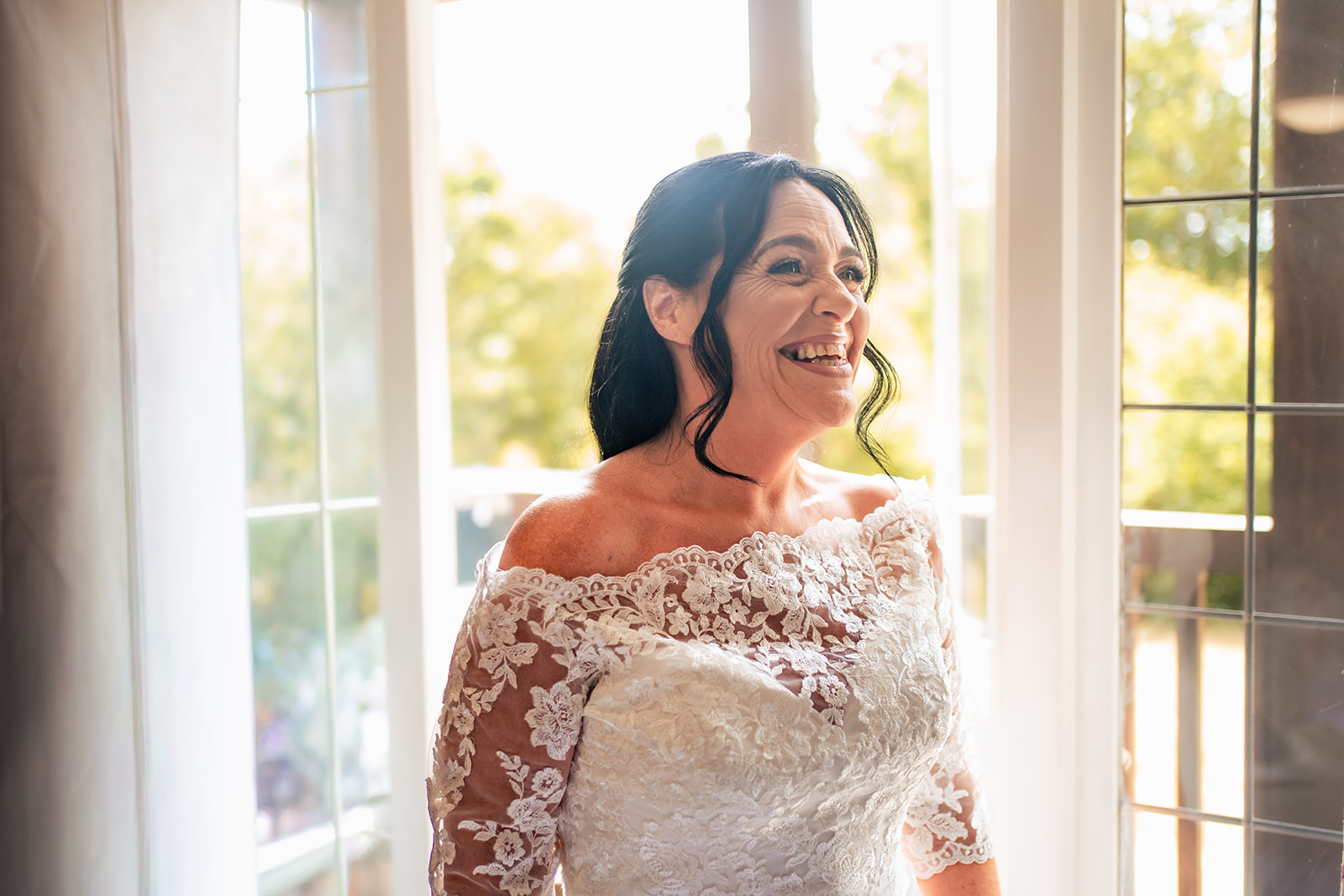 Bride in soft window light before her wedding at Farnham House Hotel, Surrey