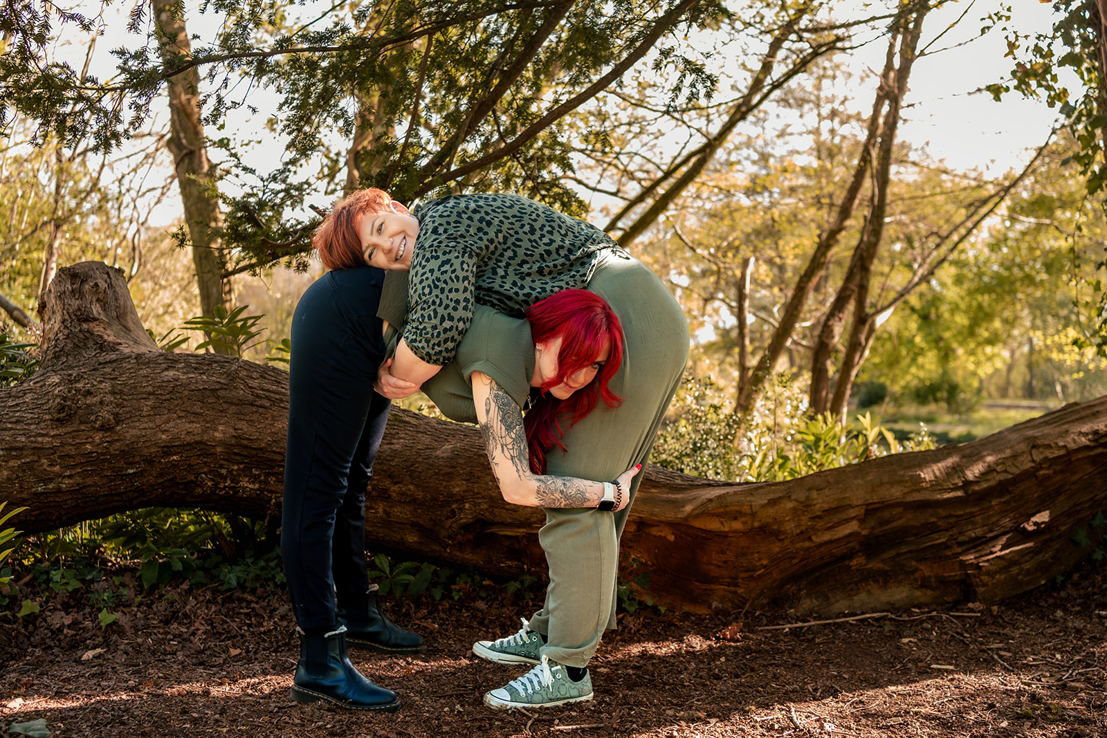 Playful moment on a fallen log at an 80s themed engagement shoot