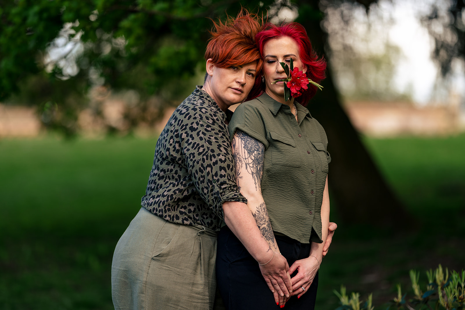 Awkward 80s style engagement portrait of a same-sex couple in the woods
