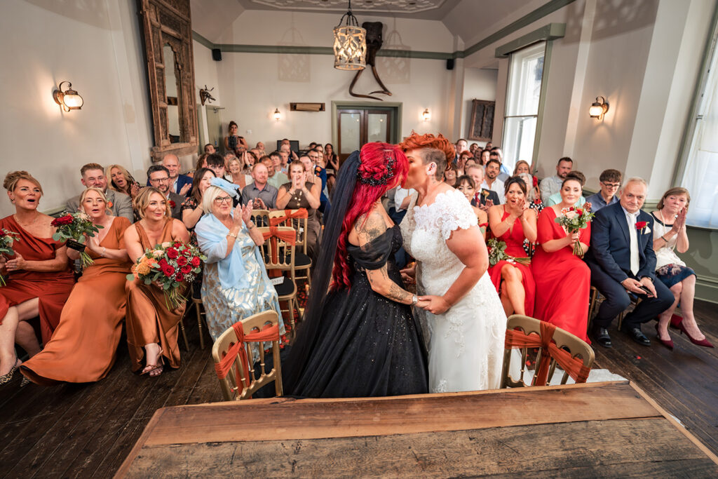 Two brides share their first kiss during their ceremony at The Elephant at Pangbourne, Berkshire