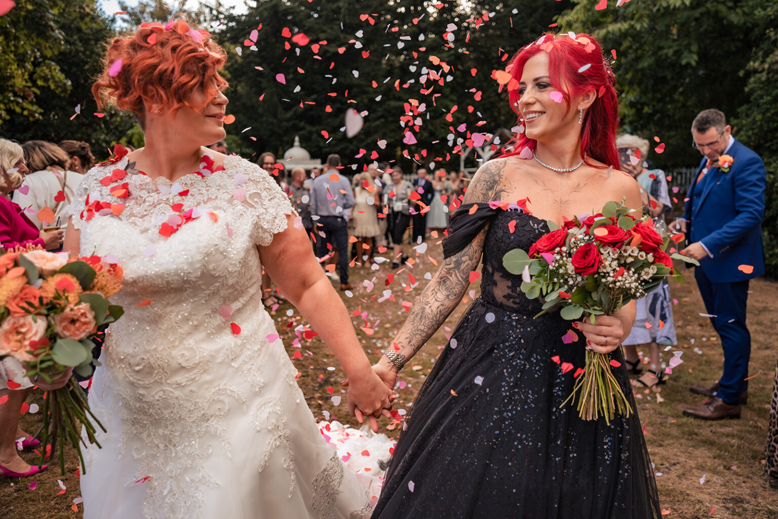 Two brides walk through colourful confetti at The Elephant at Pangbourne, Berkshire