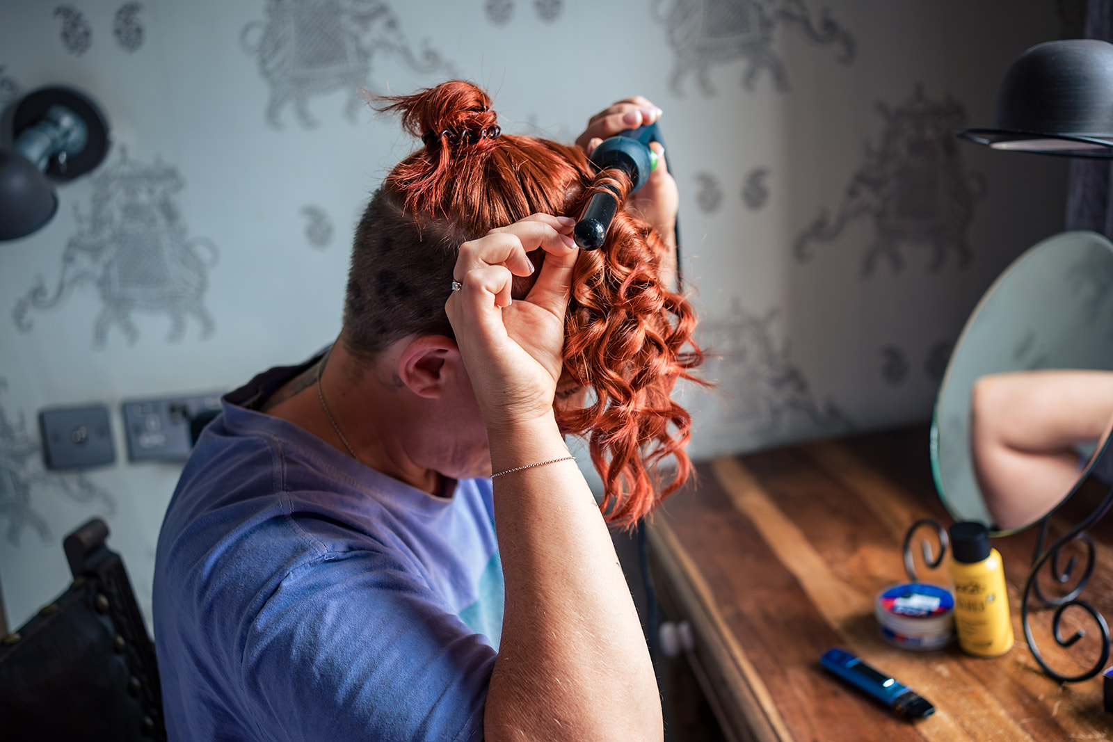 Bride curling her hair before a wedding at The Elephant at Pangbourne, Berkshire