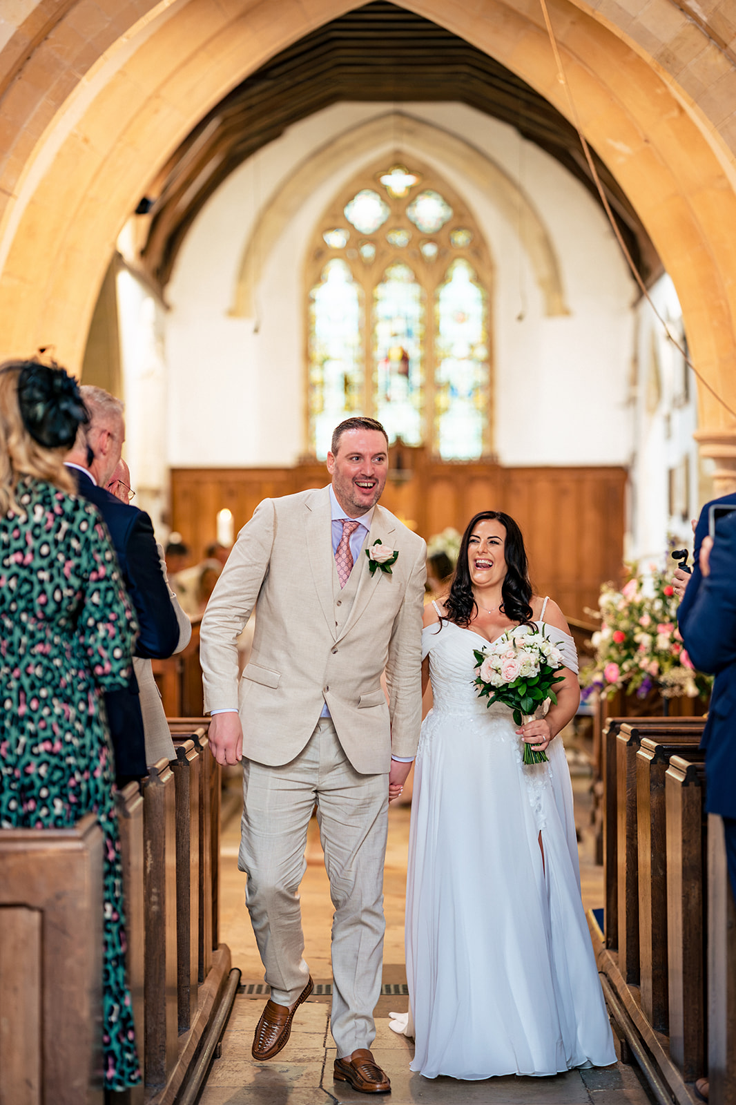 Newlyweds walking back down the aisle at St Thomas à Becket Church, Warblington