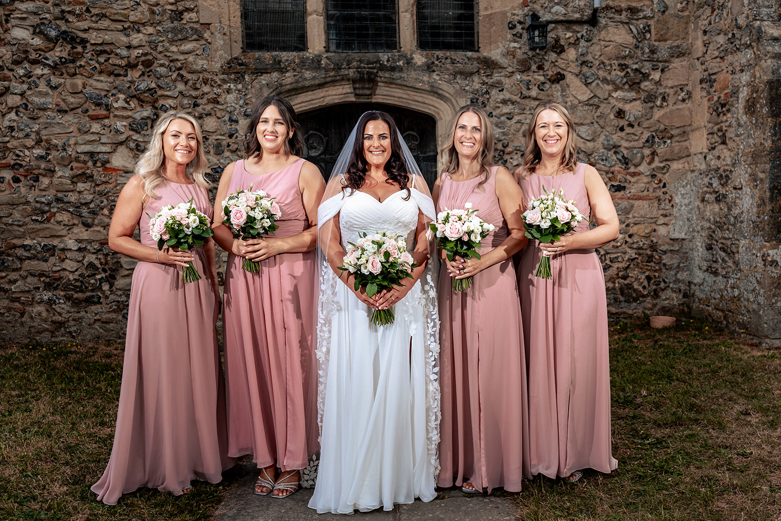Bride with her bridesmaids outside St Thomas à Becket Church, Warblington