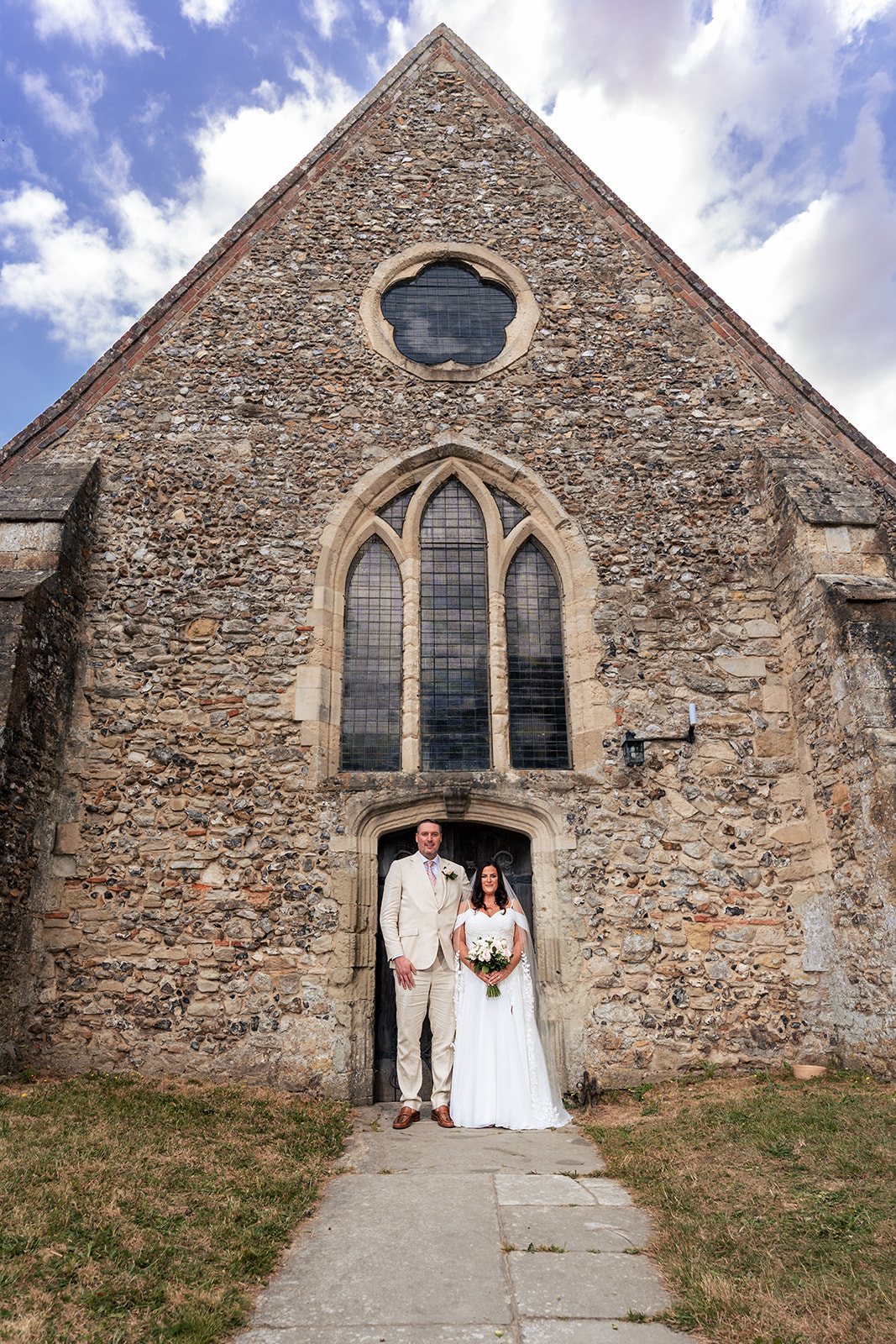 St Thomas à Becket Church in Warblington, Hampshire, with the bride and groom in the doorway