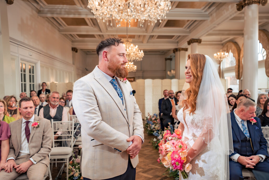 Bride and groom during their flash-lit ceremony in the chandelier ballroom at The Queens Hotel Southsea