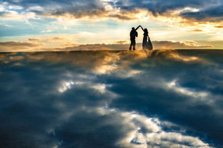 Silhouette of the bride and groom against a dramatic sunset with a mirror reflection on Southsea seafront