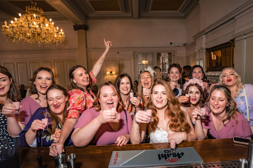 Bridesmaids raising tequila rose shots at the bar at The Queens Hotel Southsea