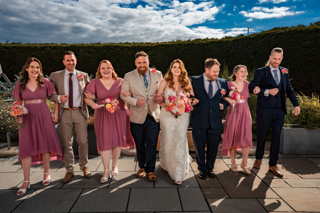 Bride, groom and bridal party walking together at The Queens Hotel Southsea