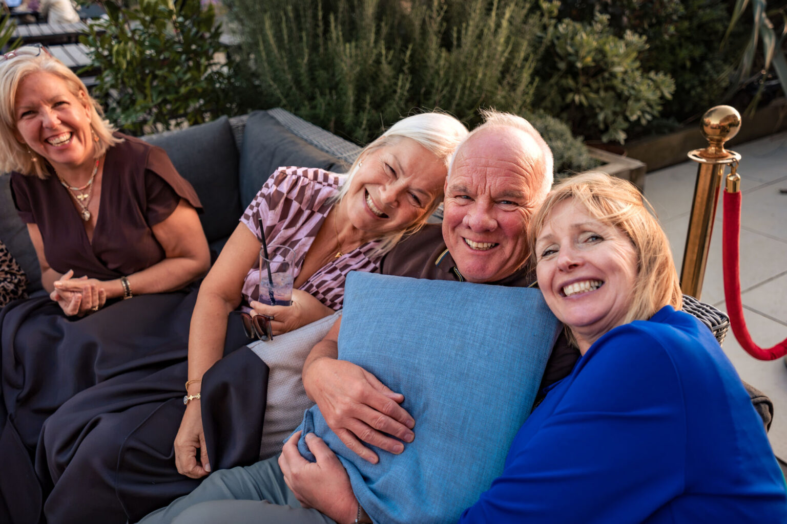 Guests laughing together on a sofa at The Queens Hotel wedding