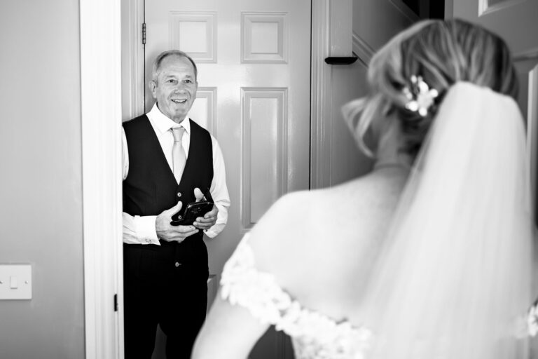 Father of the bride emotional seeing his daughter in her wedding dress, black and white