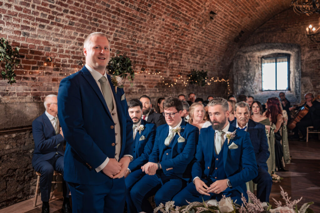 Groom and groomsmen waiting in the brick vaulted ceremony room at The Square Tower