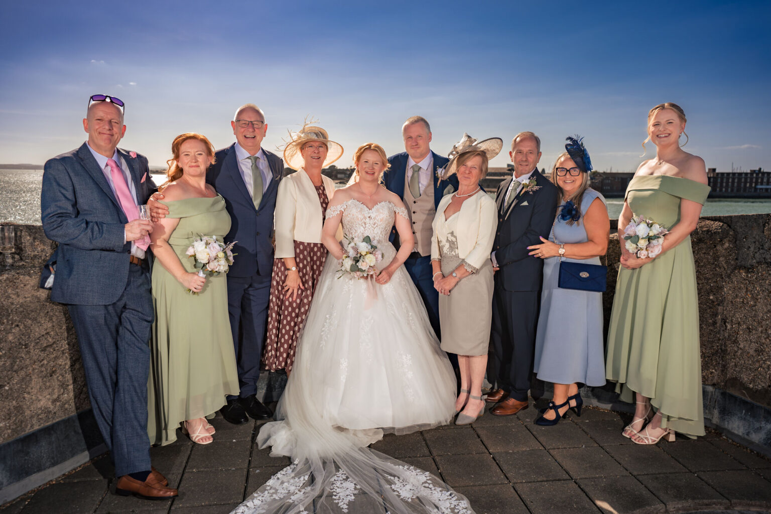 Full wedding party group photo on the rooftop of The Square Tower with Portsmouth Harbour behind