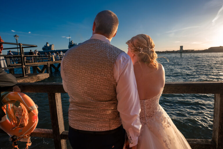 Bride, groom and guests watching HMS Queen Elizabeth leave Portsmouth Harbour
