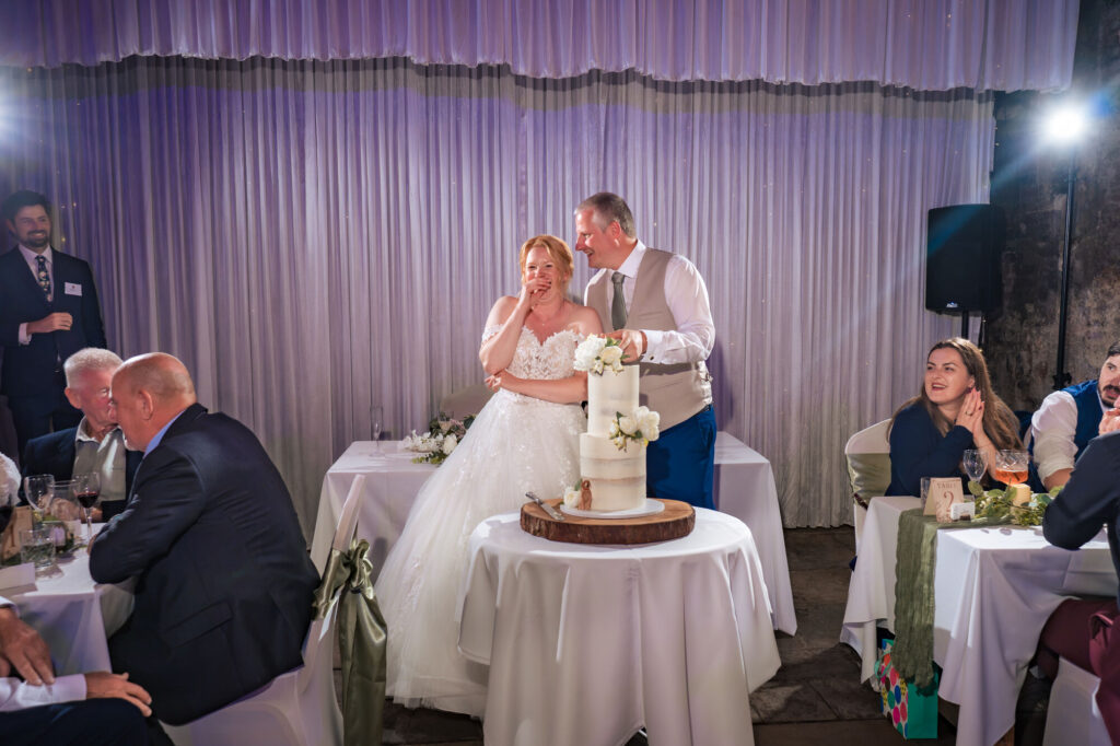 Bride and groom cutting the cake lit with flash at The Square Tower Old Portsmouth wedding