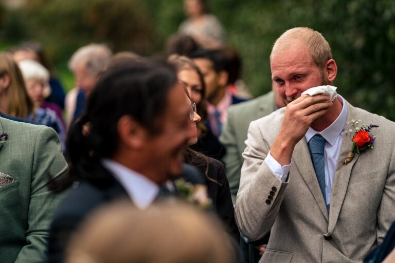 Guest wiping away happy tears during the outdoor ceremony at Houghton Lodge Gardens