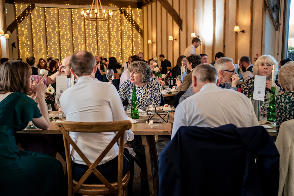 Guests at the wedding breakfast in the barn at Kimbridge Barn, Test Valley, Hampshire