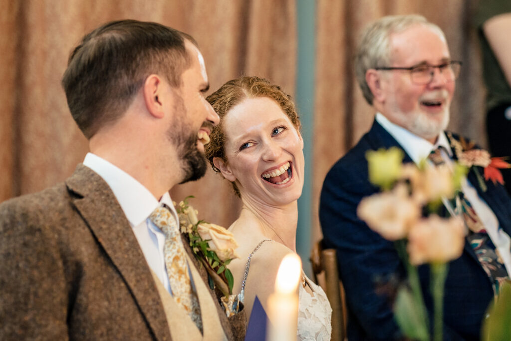 Bride laughing during the speeches at Kimbridge Barn, Test Valley, Hampshire