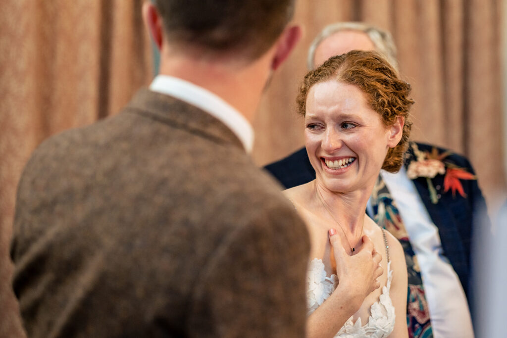 Bride smiling at the groom during the speeches at Kimbridge Barn, Test Valley, Hampshire