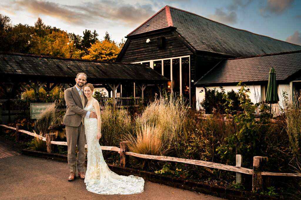 Bride and groom in front of the barn, lit with off camera flash, at Kimbridge Barn, Test Valley, Hampshire