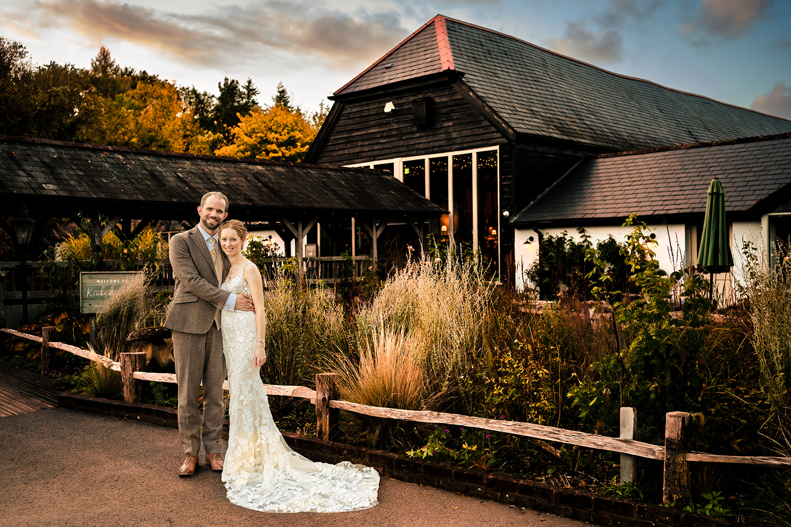 Bride and groom in front of the barn, lit with off camera flash, at Kimbridge Barn, Test Valley, Hampshire