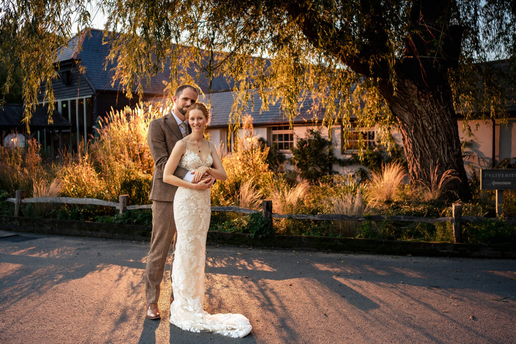 Bride and groom under a tree in a flash-lit fake sunset at Kimbridge Barn, Test Valley, Hampshire