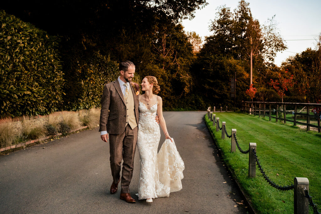 Bride and groom walking down the drive in the evening at Kimbridge Barn, Test Valley, Hampshire