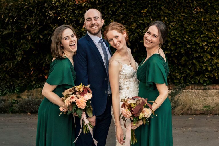 Bride and groom with bridesmaids in green at Kimbridge Barn, Test Valley, Hampshire