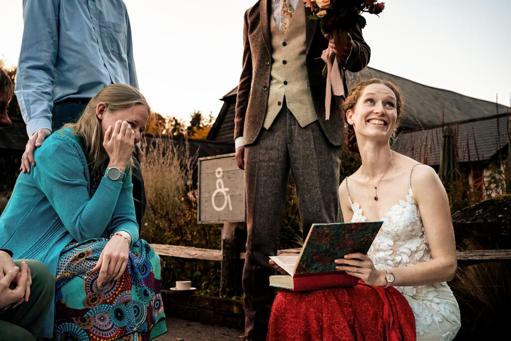 Bride laughing with a guest at Kimbridge Barn, Test Valley, Hampshire