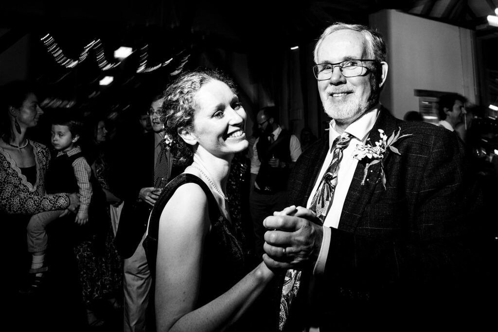 Bride dancing with a guest, black and white, at Kimbridge Barn, Test Valley, Hampshire