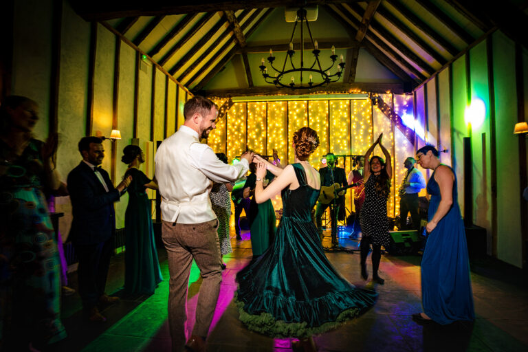 Packed dancefloor with colourful lights in the barn at Kimbridge Barn, Test Valley, Hampshire