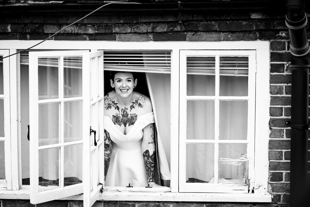 Bride waving from the window at Newtown House Hotel, Hayling Island