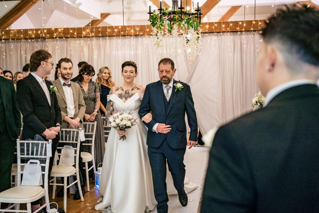 Two brides walking down the aisle at Newtown House Hotel, Hayling Island