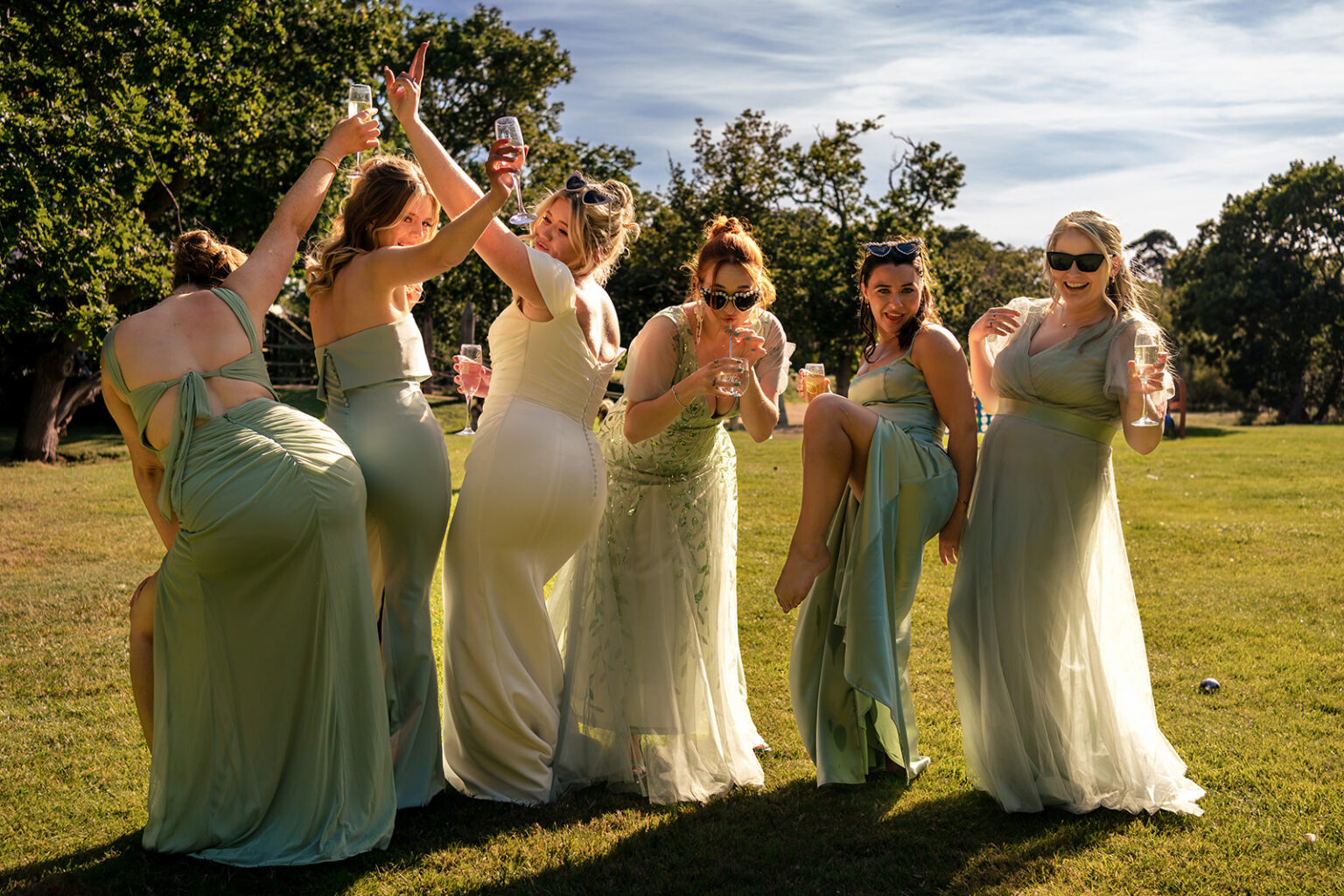 Bridesmaids dancing in the sunshine on the lawn