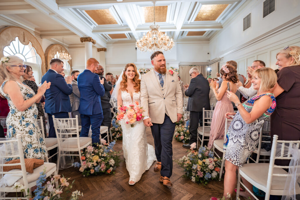 Bride and groom walking back down the aisle at The Queens Hotel Southsea