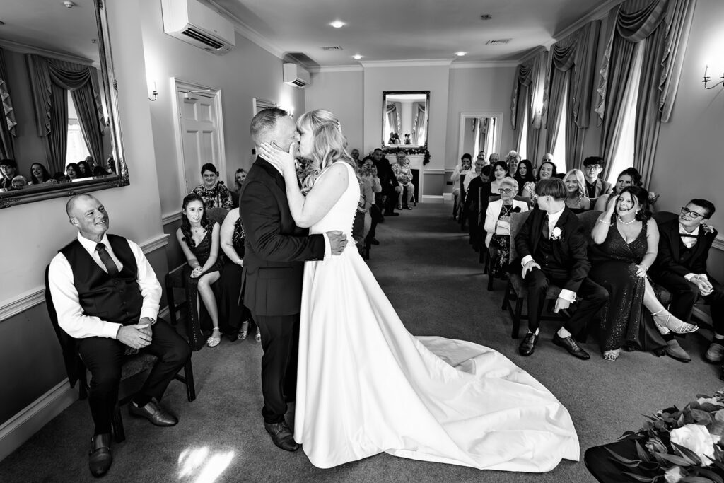 Bride and groom signing the register, black and white, at Portsmouth Register Office, Hampshire