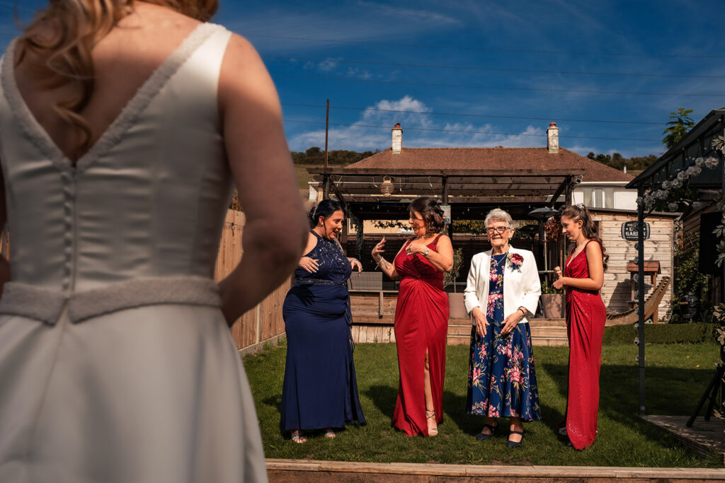 Bridesmaids in red with the bride in the garden on the morning of a Portsmouth wedding
