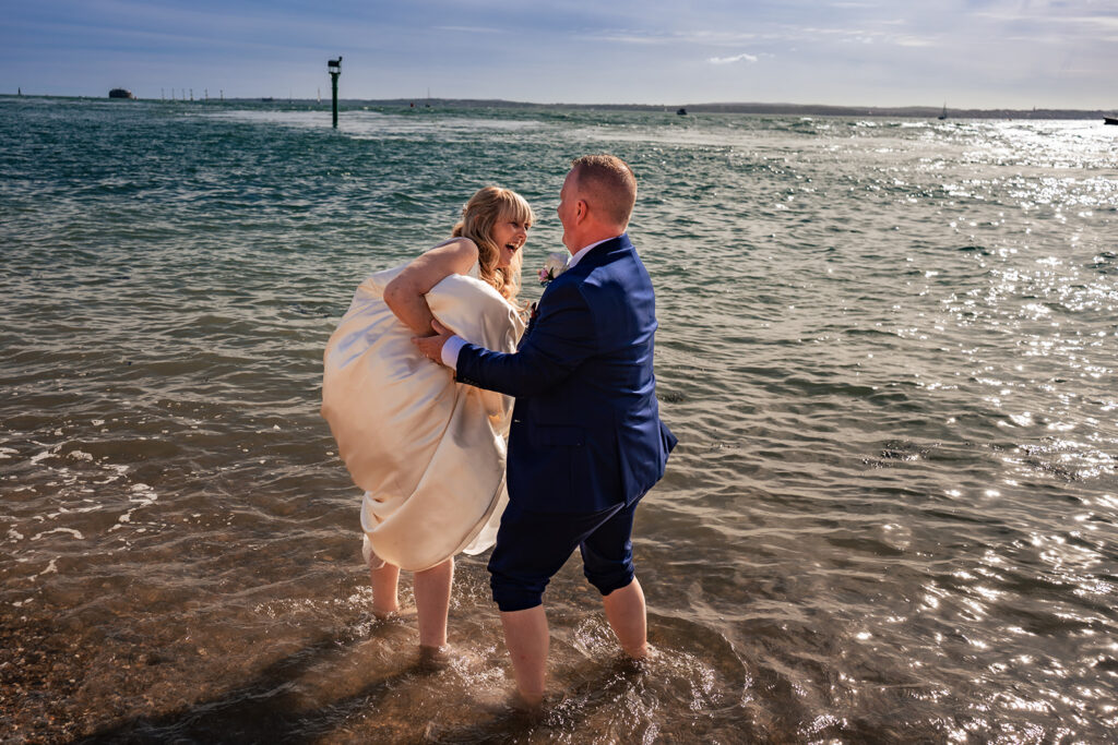 Bride and groom paddling in the sea at the Hot Walls, Old Portsmouth